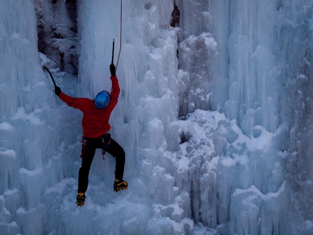 Photo alpinist ascenting a frozen waterfall in ice park, ouray.