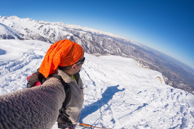 雪を頂いた山でアルピニスト撮影selfie