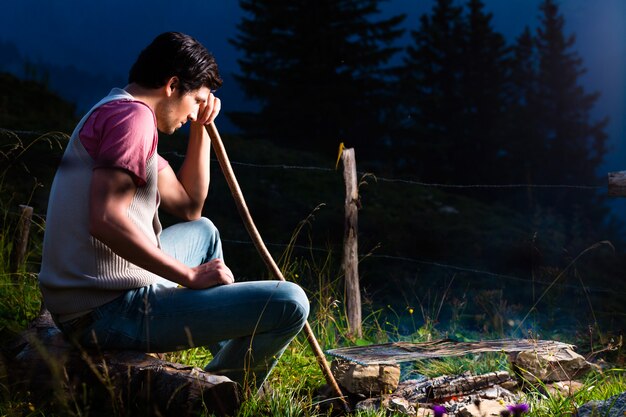 Alps - Man at campfire in Bavarian mountains