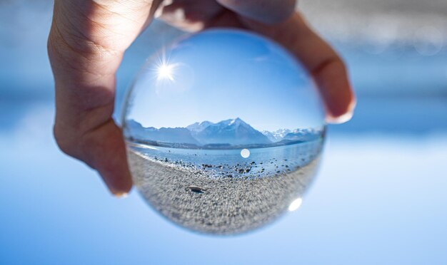 Alps mountains and lake inside crystal ball