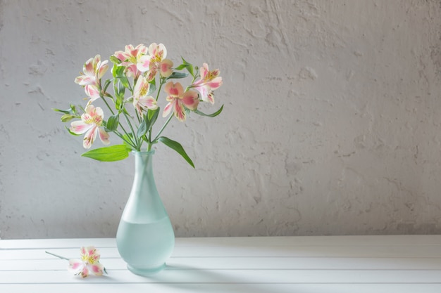 Alstroemeria in vase on grunge white