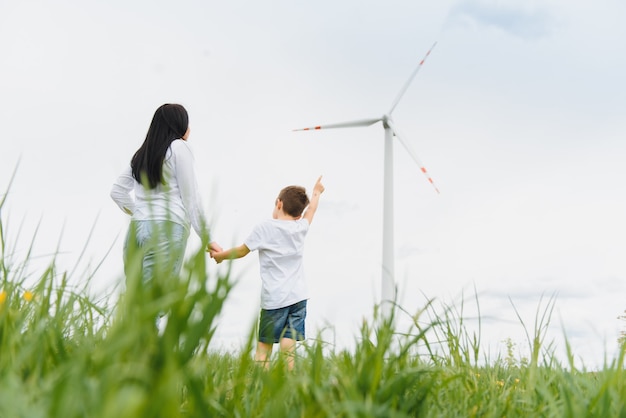 Alternatieve energie, windmolenpark en fijne tijd met je gezin. Gelukkige moeder op de weg met zijn zoon op vakantie en ontsnappen naar de natuur.