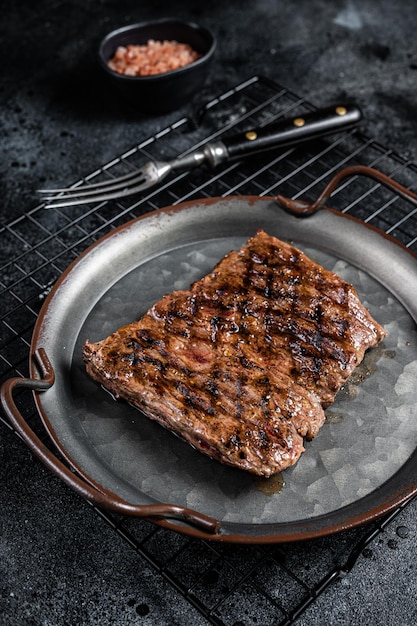 Alternative choice steak Grilled Skirt or Machete beef meat Black background Top view