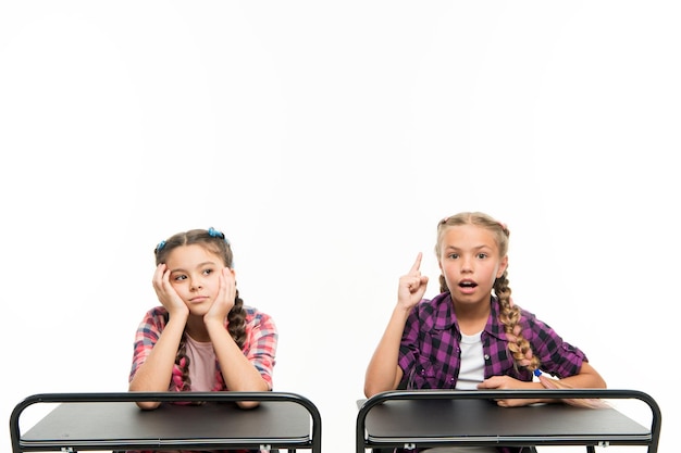 Alternative education idea Cute children sitting at desks isolated on white Small girls learning in school of primary education Little kids getting formal education Compulsory education is free