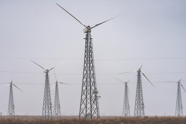 Alternative energy shot of wind turbine farm during foggy morning.