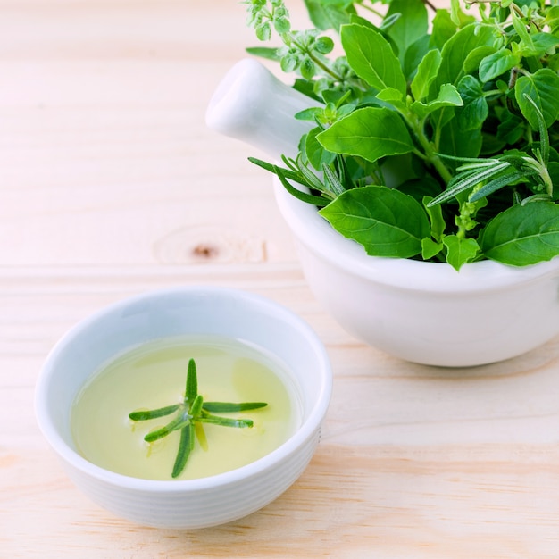 Alternative health care fresh herbs on wooden background.