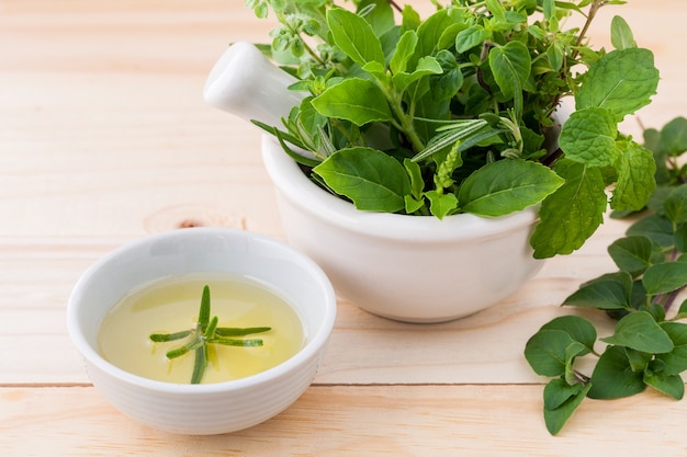 Alternative health care fresh herbs on wooden background.