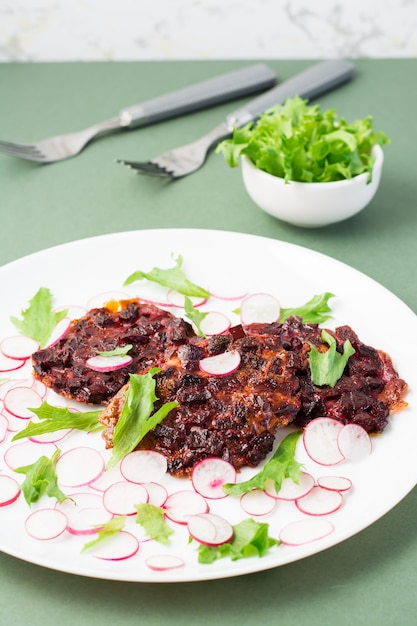 An alternative to meat protein is beet steak with vegetables and herbs on a plate. Flexitarian diet. Vertical view