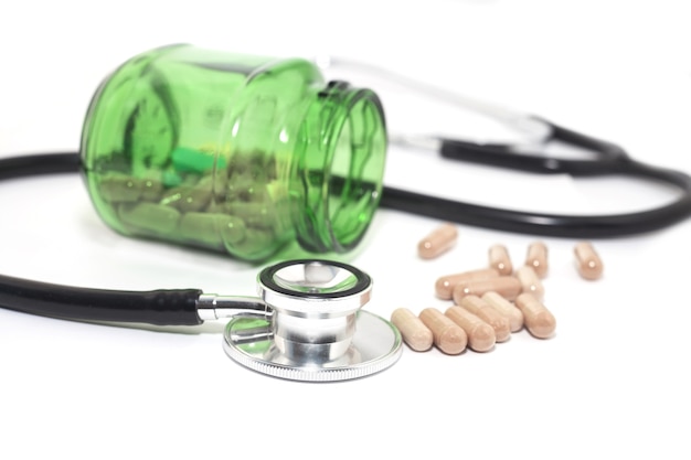 Alternative medicine  capsule with stethoscope on white background