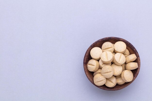 Alternative medicine tablets on a wooden spoon