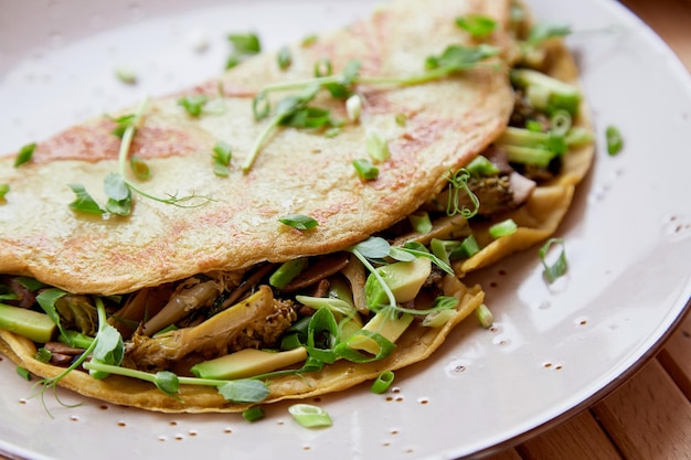 Alternative vegan pancakes filled with mushrooms pea sprouts avocado healthy breakfast