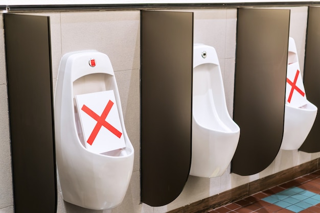 화장실에서 변기 소변 그릇의 사회적 거리 규칙에 대한 대체 사용 표시. 대유행 보호 조치. 사회적 분산 개념
