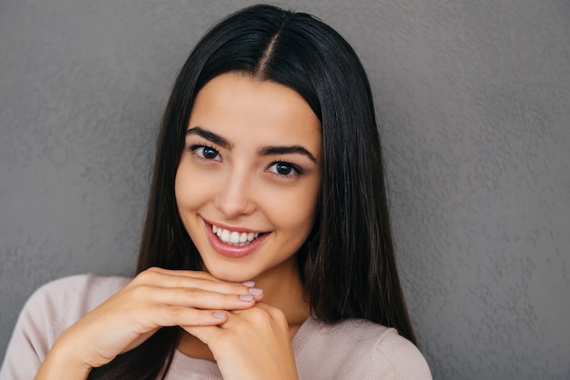 Altijd in een goed humeur. Mooie jonge vrouw hand in hand op kin en glimlachen