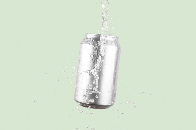 浅い緑色の背景に水のスプラッシュがあるアルミニウム製のビールまたはソーダ飲料