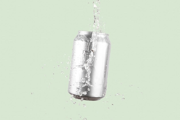 Photo aluminium beer or soda drinking can with water splash on light green background