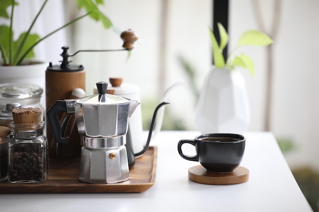 Aluminium mokapot en zwarte koffiekop met koffiespul