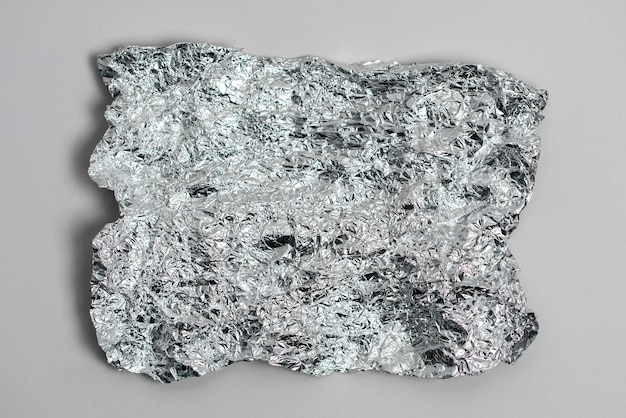 The aluminium silver crumpled foil abstract texture