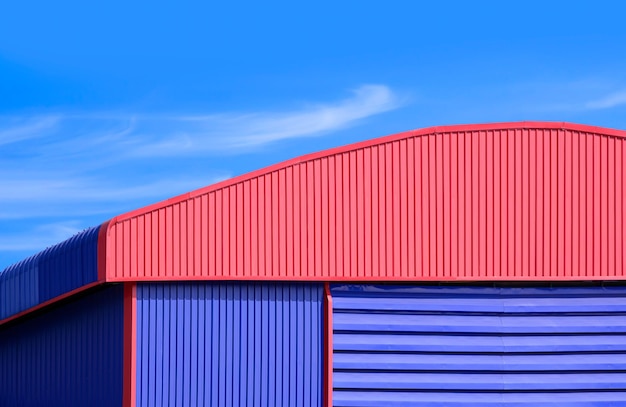 사진 파란색 환기 루버와 파란색 하늘을 가진 빨간색  지붕을 가진 알루미 창고 건물
