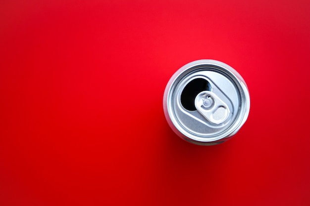 Photo aluminum can opened on red background with copy space