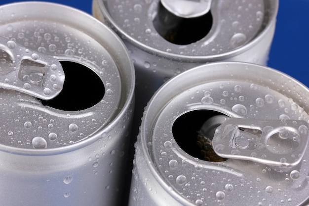 Aluminum cans with water drops on blue background