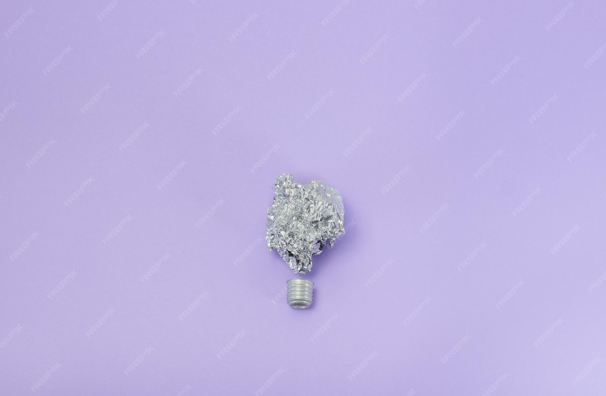 Premium Photo Aluminum foil light bulb on very peri background