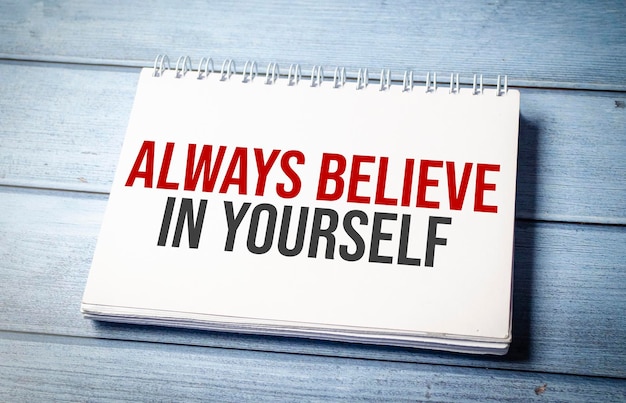 ALWAYS BELIEVE IN YOURSELF text on blue wooden background