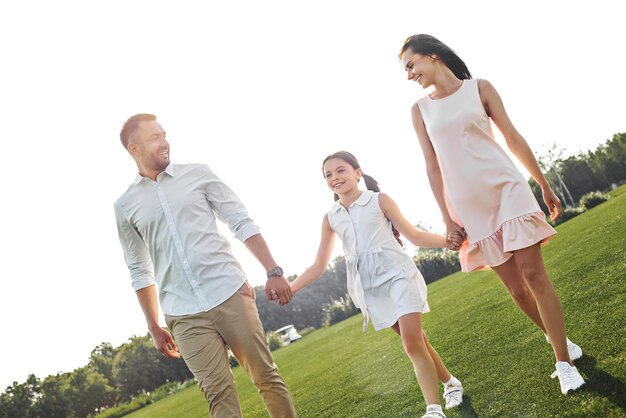 Always happy together full length of little happy girl walking with her parents in the