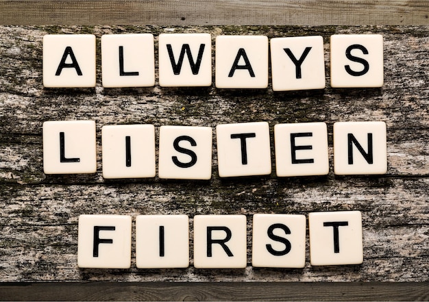 木製立方体の「Always Listen First」サイン