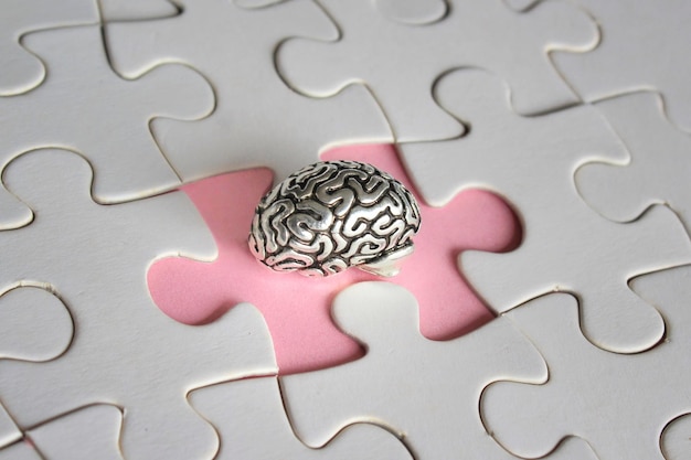 Photo alzheimer amnesia mental health concept brain model and missing puzzle pieces