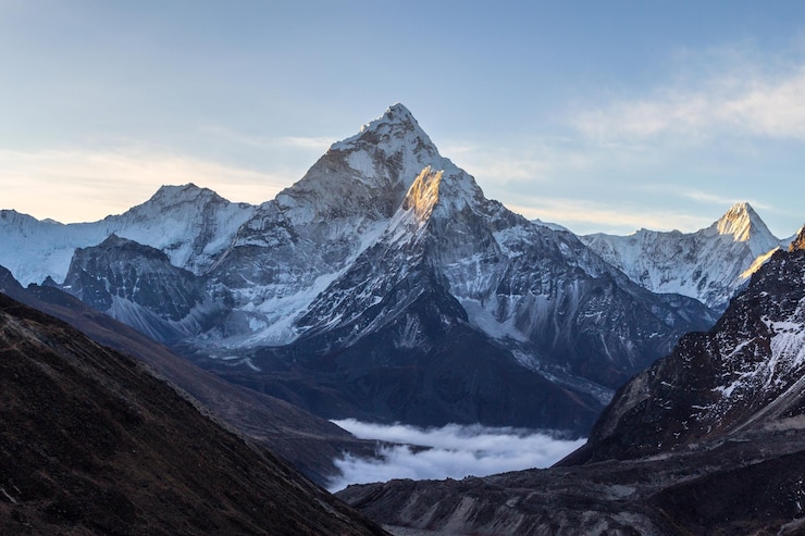 Photo ama dablam mountain at sunrise and blue sky. sun illuminates slopes. himalayan mountains, nepal.