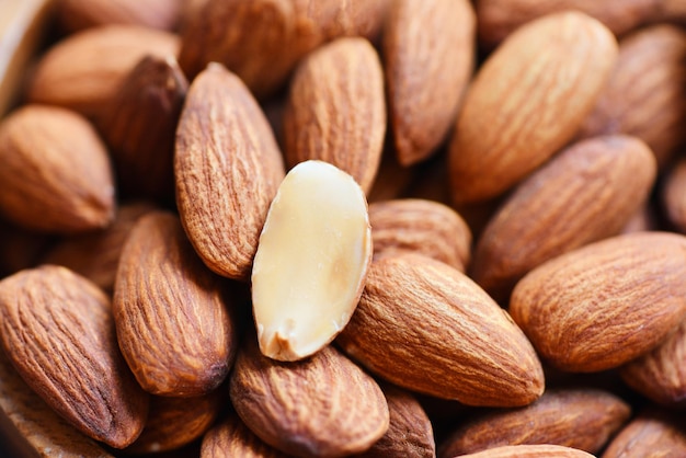 Amandelen op de achtergrond bovenaanzicht op tafel, close-up van geroosterde amandelnoten, natuurlijk eiwitrijk voedsel en voor een snack