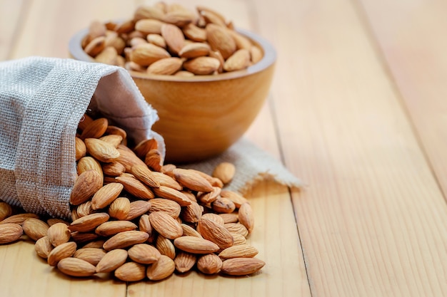 Foto amandelen schenken uit zak met houten beker