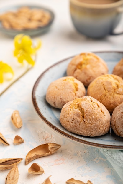 Amandelkoekjes en een kopje koffie op een witte betonnen achtergrond Zijaanzicht selectieve focus