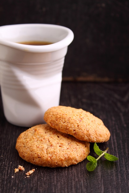 Amandelkoekjes op een zwarte achtergrond met een kop van koffie