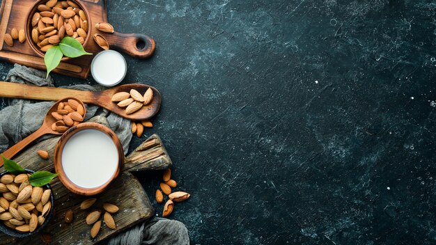 Amandelmelk en amandelen op zwarte stenen achtergrond Bovenaanzicht Vrije ruimte voor uw tekst