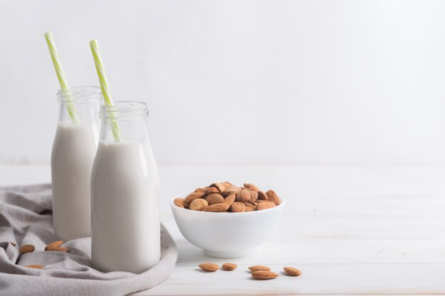 Amandelmelk en servet op een witte houten lijst