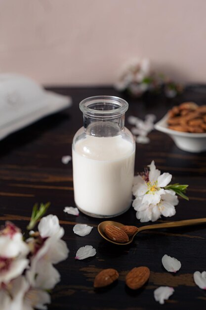 Foto amandelmelk met amandelen en amandelbloesems op tafel het veganistische alternatief voor traditionele melk
