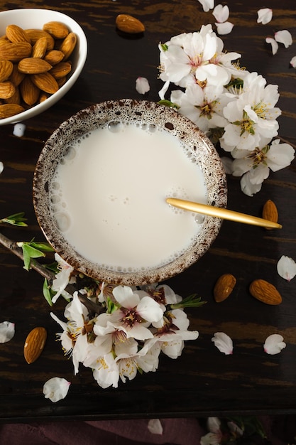 Foto amandelmelk met amandelen en amandelbloesems op tafel het veganistische alternatief voor traditionele melk