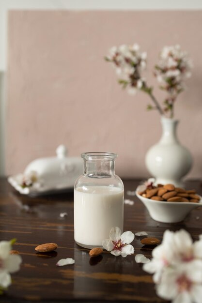 Foto amandelmelk met amandelen en amandelbloesems op tafel het veganistische alternatief voor traditionele melk