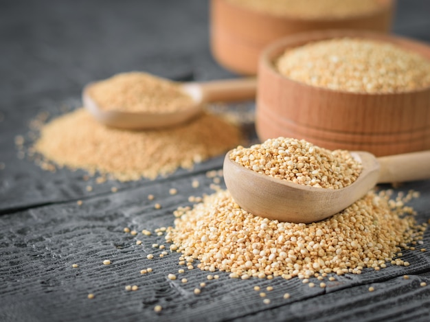 Amarant en quinoa zaden en twee houten lepels op een tafel.