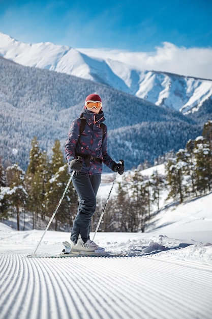 Amateur vrouwelijke skiër rustend op de fluwelen helling op een zonnige dag in de bergen