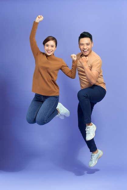 Amazed Asian couple on a blue background