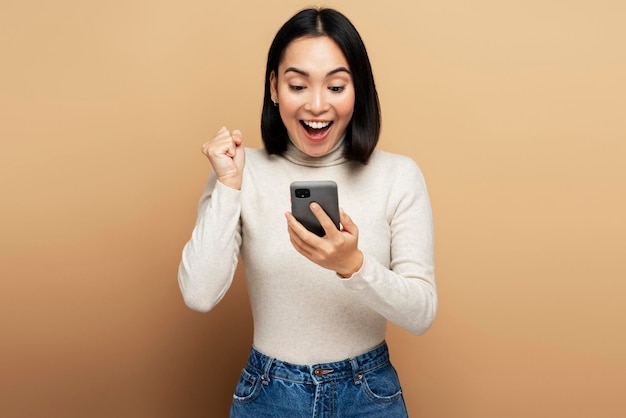 Amazed brunette girl using mobile phone with surprised expression