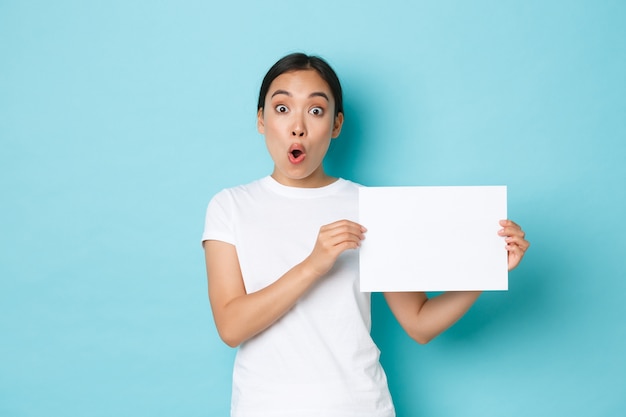 Amazed and excited asian girl in white t-shirt