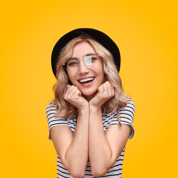 Amazed female in hat looking at camera