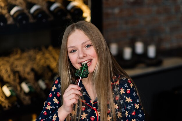 Amazed funny kid lick candy lollipop during winter holidays