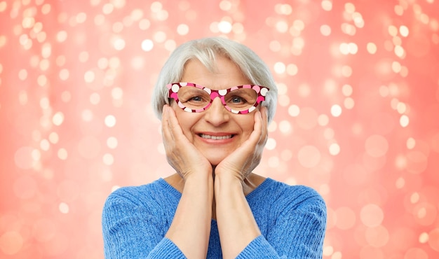 Photo amazed funny senior woman with big party glasses