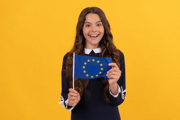 Amazed kid hold european union flag yellow background european union