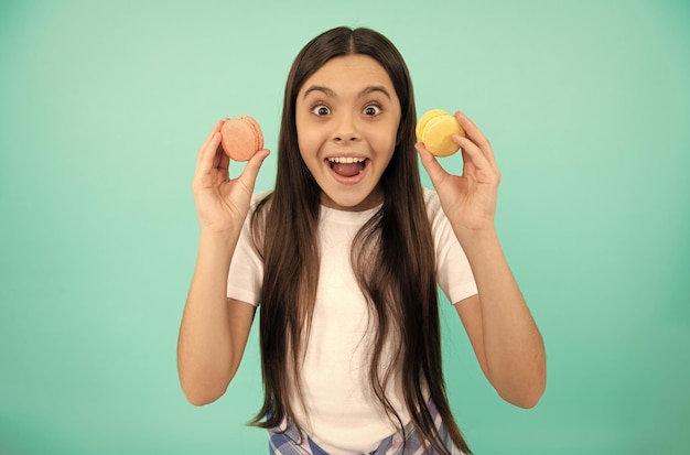 Amazed kid hold french macaron or macaroon cookies amazement