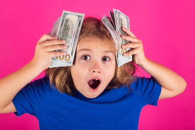 Amazed kid with hundred dollars money isolated on studio background